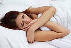 Junge Frau liegt schlafend im Bett Junge Frau liegt schlafend im Bett